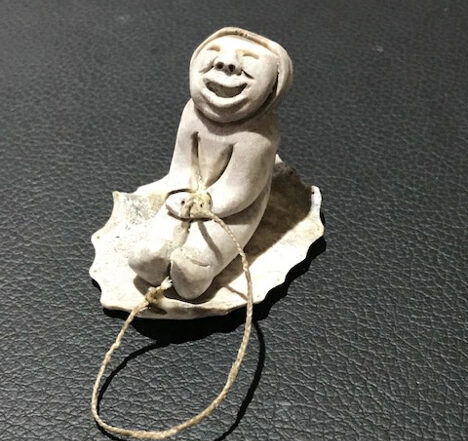 Inuit artist Silas Kayakjuak (Qayaquaq) captures the joy of a child sledding in this sculpture